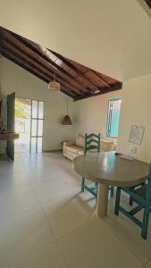 ein Wohnzimmer mit einem Tisch und einem Sofa in der Unterkunft Pousada Paradise in Coruripe