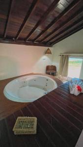 Pousada Paradise في كوروريبي: حوض كبير في غرفة مع أرضية خشبية