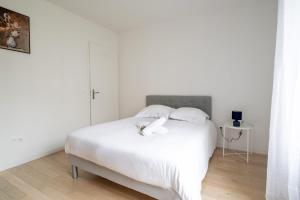 a bedroom with a white bed with two white pillows at Bright T4 with balcony in Saint-Ouen - Welkeys in Saint-Ouen