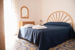 アルカモ・マリーナにあるLa perla sulla spiaggiaのベッドルーム(青いベッド1台、青い毛布付)