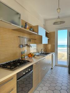 a kitchen with a sink and a stove top oven at La perla sulla spiaggia in Alcamo Marina