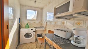 uma pequena cozinha com uma máquina de lavar roupa e um lavatório em VACAY Apartamento La Terraza em L'Escala