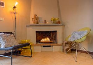 a living room with a fireplace and two chairs at Vicolo Zenone 8 Casa Esclusiva tra Natura e Arte in Garzano