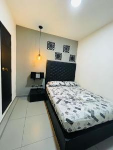um quarto com uma cama com uma cabeceira preta em Hotel Panorama Medellín em Medellín