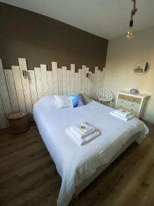 ein Schlafzimmer mit einem großen weißen Bett und einer Kommode in der Unterkunft Les balcons de Bouzigues in Bouzigues