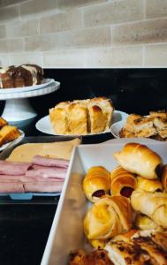 a table topped with plates of pastries and bread at Hotel Hellyus in Brasilia