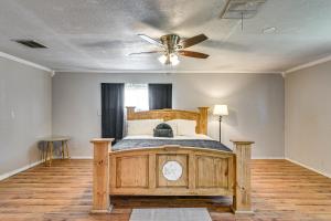 a bedroom with a wooden bed with a ceiling fan at Spacious Orange Rental about 3 Mi to Museums and Garden! in Orange