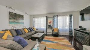 a living room with a couch and a table at Escape to Raleigh Ave - Steps from the Beach in Atlantic City