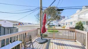 a red umbrella sitting on top of a wooden deck at Escape to Raleigh Ave - Steps from the Beach in Atlantic City