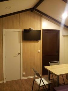 Cette chambre dispose d'une porte et d'une télévision murale. dans l'établissement CAMPING-BUNGALOWS-CABAÑAS LA VERA, à Jarandilla de la Vera