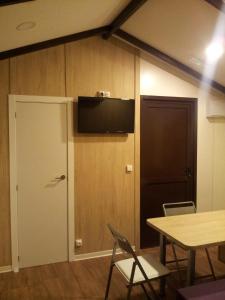 a room with a door and a television on the wall at CAMPING-BUNGALOWS-CABAÑAS LA VERA in Jarandilla de la Vera