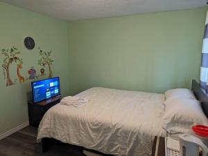 una camera con letto e scrivania con TV di The home of peace a Brantford