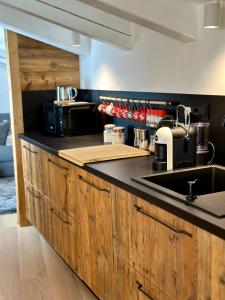 a kitchen with wooden cabinets and a sink at Si Mezzana Home in Mezzana