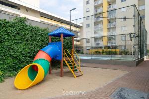 een speeltuin met een glijbaan voor een gebouw bij Belo Apto com Vista Mar em Barra Velha VAC2205 in Barra Velha