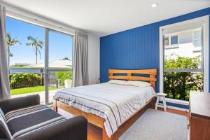 a bedroom with a bed and a large window at Waihi Wonder - Waihi Holiday Home in Waihi Beach