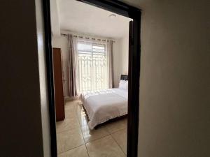 a reflection of a bedroom with a bed in a mirror at Alma Residence Apartment in Rubavu