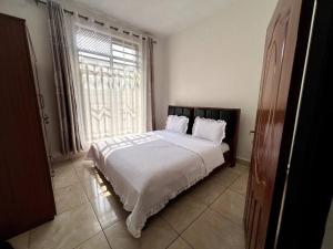a bedroom with a bed and a large window at Alma Residence Apartment in Rubavu