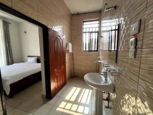 a bathroom with a sink and a bed at Alma Residence Apartment in Rubavu