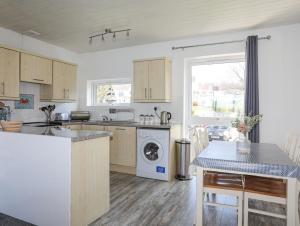 a kitchen with a washer and dryer in it at Min Y Don in Port Dinorwic