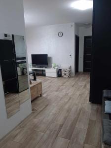 sala de estar con suelo de madera y TV de pantalla plana en Apartment de Lux in regim hotelier, en Oradea