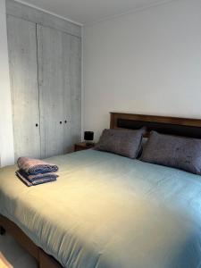 1 dormitorio con 1 cama grande y toallas. en Departamento Estudio, centrico, en Temuco