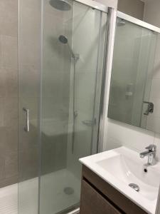 a bathroom with a glass shower and a sink at Departamento Estudio, centrico in Temuco