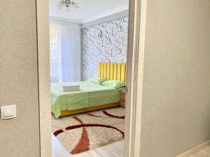 um quarto com uma cama com uma colcha verde em Apartament comfort Centru em Chisinau