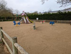 a playground with slides and a play equipment at Camping de Lanven in Plomeur