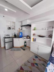 a kitchen with white cabinets and a counter top at Avida Tower 1 L21 staycation rm1002 in Iloilo City