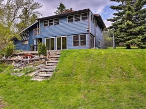a blue house sitting on top of a lush green field at Hygge House on the Creek in Rapid City