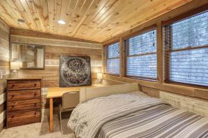 a bedroom with a bed and a desk and windows at Hygge House on the Creek in Rapid City