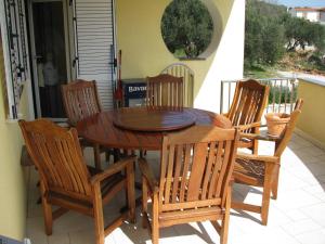 a wooden table and chairs on a patio at Apartment Megi in Tribunj