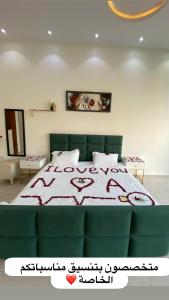 a bed with a green couch in a bedroom at Chalet LV in Hafr Al Baten