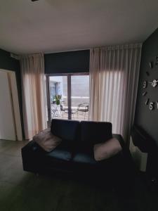 uma sala de estar com um sofá em frente a uma janela em Habitación Córdoba Capital centro cerca de todo em Córdoba