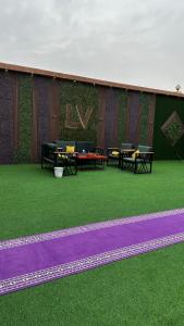 a building with two ping pong tables on the grass at Chalet LV in Hafr Al Baten