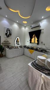 a restaurant with a counter with plates on it at Chalet LV in Hafr Al Baten