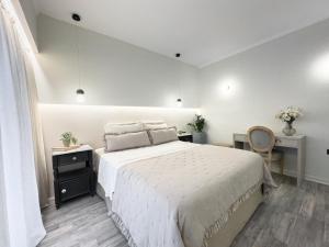 a white bedroom with a large bed and a desk at Ixia home in Ixia