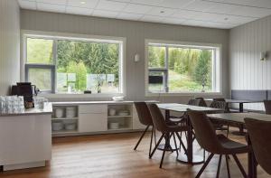 a dining room with tables and chairs and windows at Hótel Laugarvatn in Laugarvatn