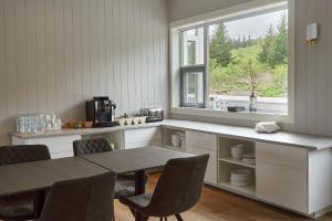 a kitchen with a table and chairs and a window at Hótel Laugarvatn in Laugarvatn