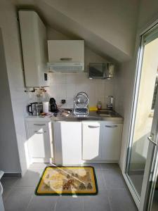 una cucina con armadi bianchi e un tappeto sul pavimento di Studio 1pièce cosy Paris-Disney a Vaires-sur-Marne