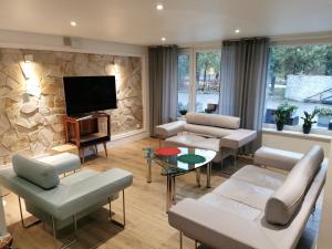 a living room with white furniture and a flat screen tv at APARTAMENT Olaf in Baryczka