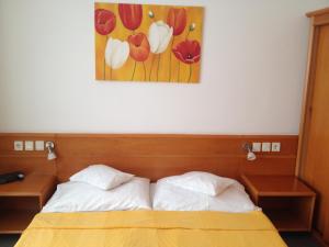 a bedroom with a bed and a painting of flowers at Hotel Apart Hotel in Hévíz