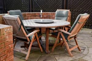 a wooden table with four chairs around it at Meadowsweet House in Stockton-on-Tees