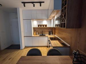 a kitchen with white cabinets and a table and chairs at Mountain Oasis Bjelasnica in Bjelašnica