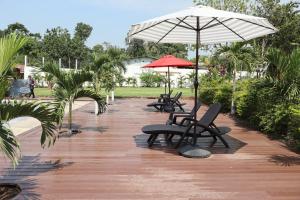- une rangée de chaises et de parasols sur la terrasse dans l'établissement Villa Casa Encantadora, à Retalhuleu