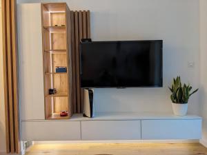 a flat screen tv sitting on top of a entertainment center at Mountain Oasis Bjelasnica in Bjelašnica +9 photos