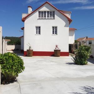 ein weißes Haus mit rotem Dach in der Unterkunft Apartamento cerca playa 3 in Puentedeume