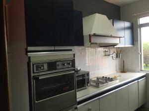uma cozinha com armários pretos e um forno com placa de fogão em Apartamento cerca playa 3 em Puentedeume