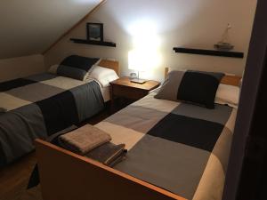 um quarto com 2 camas e uma mesa com um candeeiro em Apartamento cerca playa 3 em Puentedeume