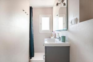 a bathroom with a sink and a mirror at Newly renovated cozy apartment on a hill in Arenys de Mar